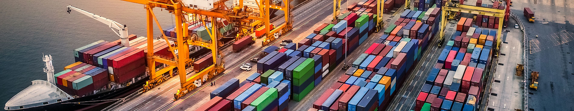 Hafen mit Containerschiffen und Kräne, Sonnenuntergang reflektiert eine geschäftige, dynamische Atmosphäre.